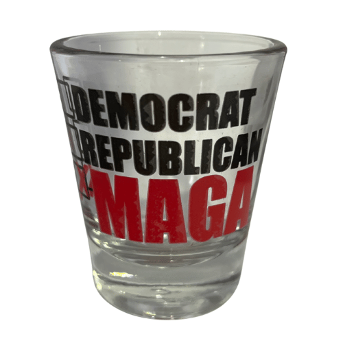 MAGA Checklist shot glass showcasing empty boxes for DEMOCRAT and REPUBLICAN with bright 'MAGA' and red 'X' design in a bar setting.