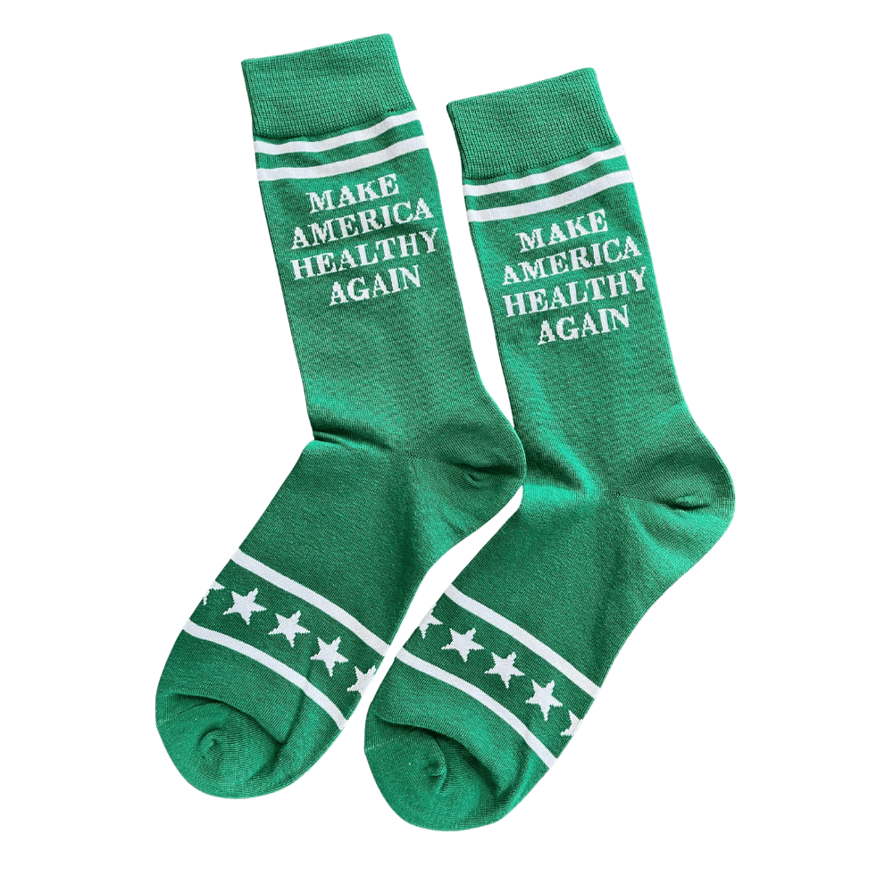 Make America Healthy Again socks in green with white lettering and star accents, displayed casually on a table, perfect for rallies and everyday wear.