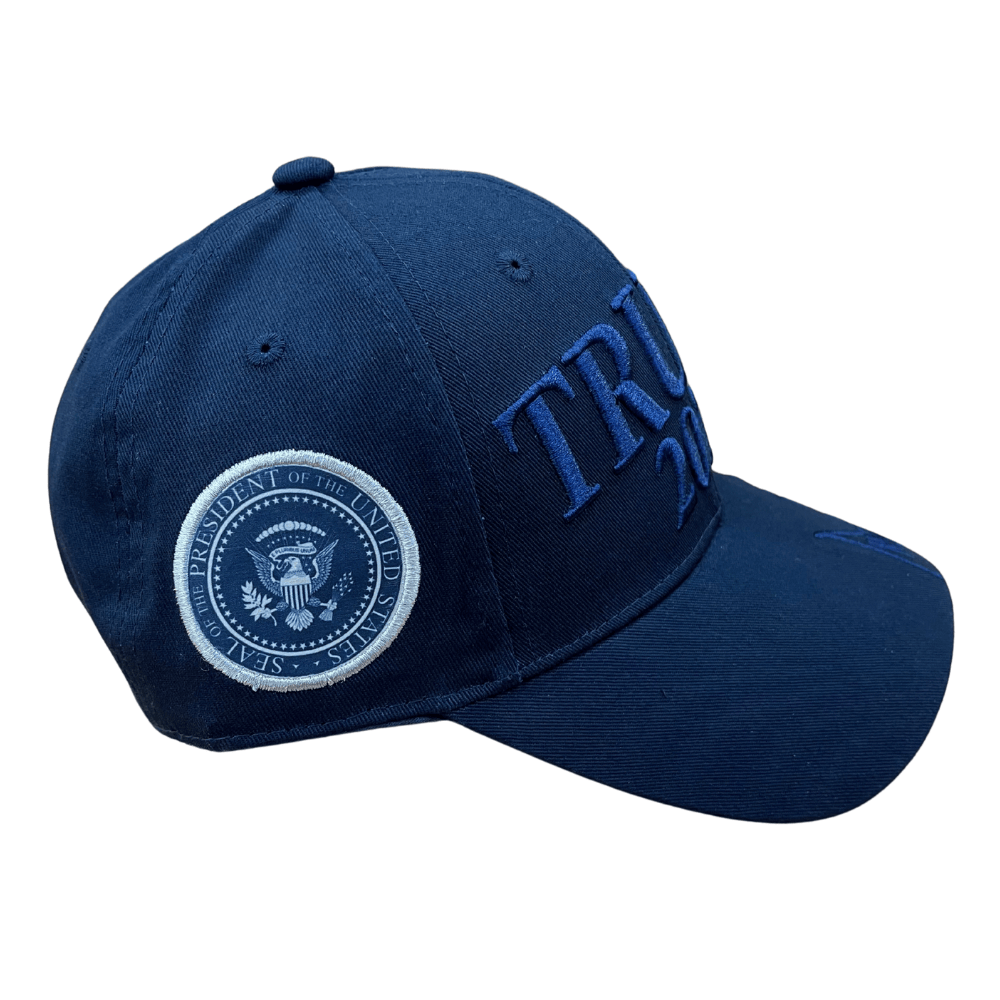 Navy Trump 2028 Signature Hat with tone-on-tone embroidery, U.S. flag, and Presidential Seal, displayed on a table against a neutral background.