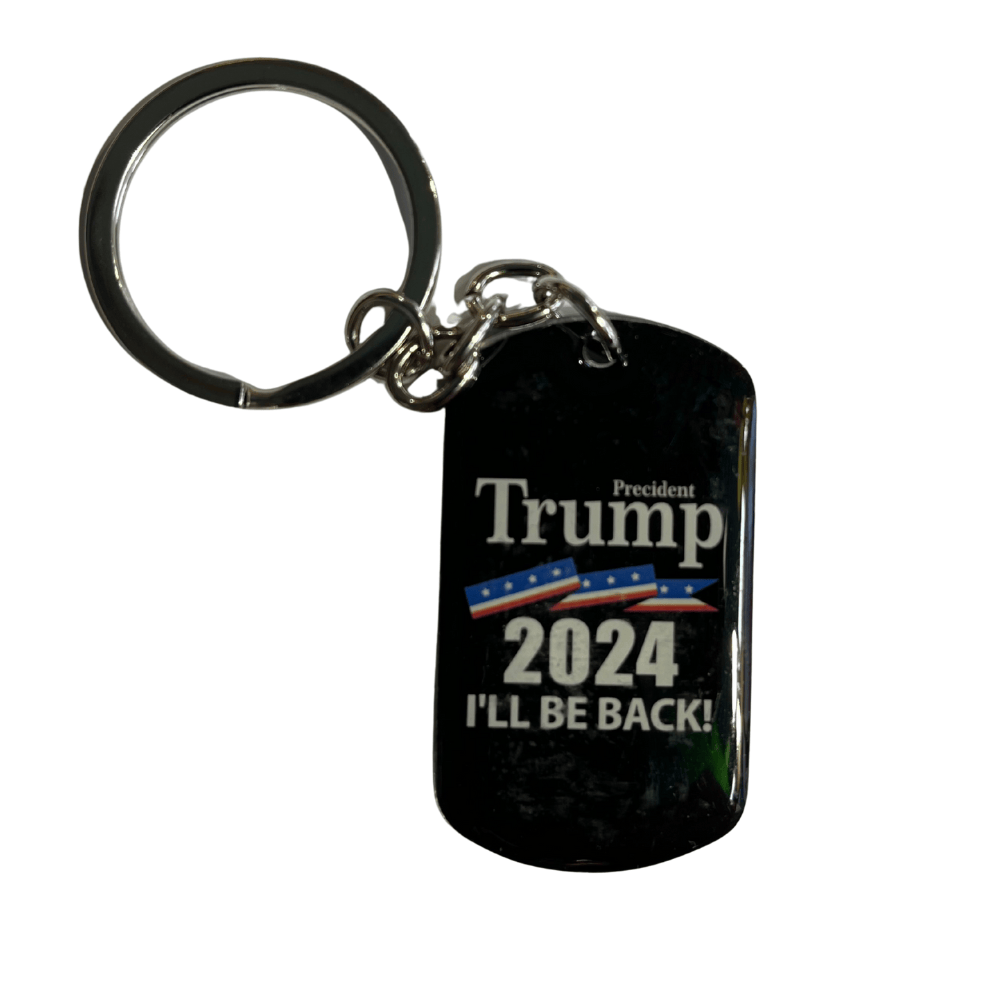 Trump 2024 I'll Be Back Dog Tag Keychain with bold black background and white lettering hanging from a set of keys in a casual setting.