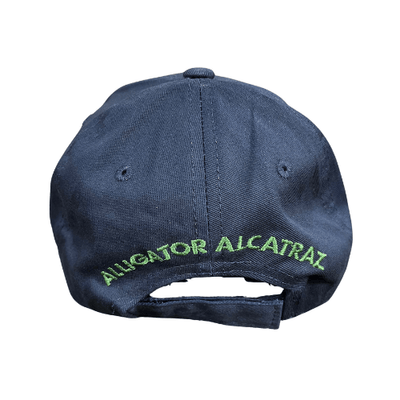 Alligator Alcatraz Navy Hat with bold green and yellow embroidery on a deep navy blue base, featuring a colorful illustration of an alligator on the bill.