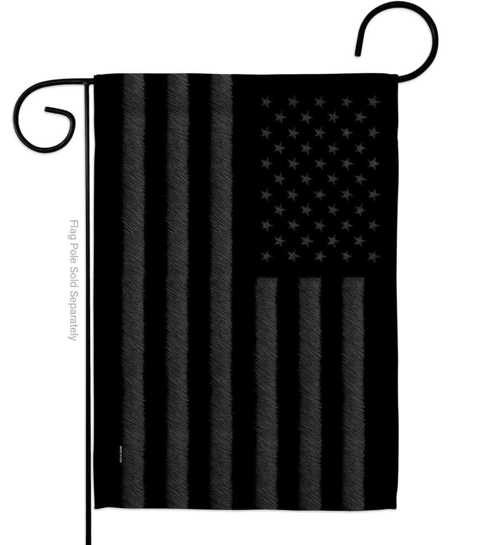 Blacked Out USA garden flag featuring a striking design displayed outdoors in a garden setting, emphasizing its bold patriotic statement.