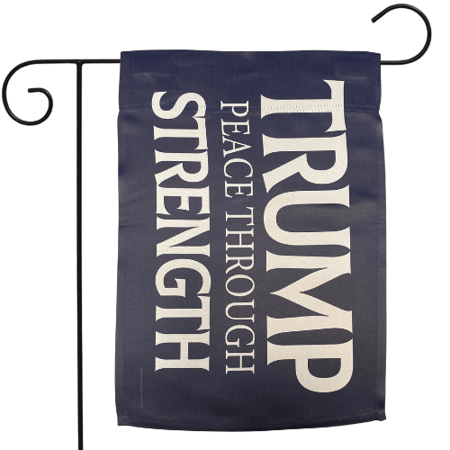Blue Trump Peace Through Strength Garden Flag with bold slogan displayed on an outdoor pole in a well-kept garden.