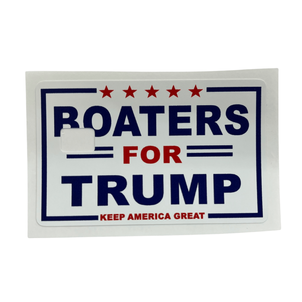 Boaters for Trump Credit Card Cover with blue lettering and red stars displayed on a wooden table, highlighting its vibrant design.