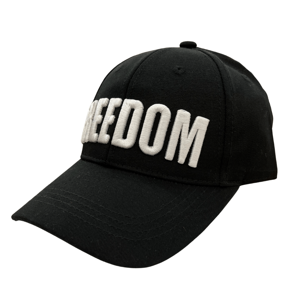 Charlie Kirk Freedom Black Hat featuring bold white 'FREEDOM' embroidery, displayed on a wooden table with a rustic background.
