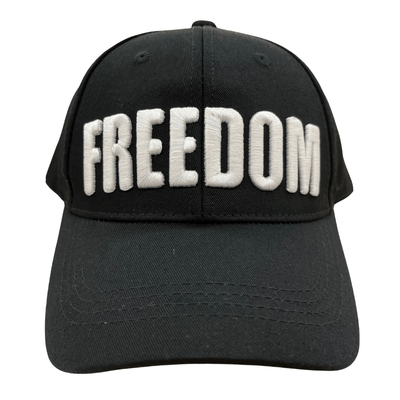 Charlie Kirk Freedom Black Hat featuring bold white 'FREEDOM' embroidery, displayed on a wooden table with a rustic background.