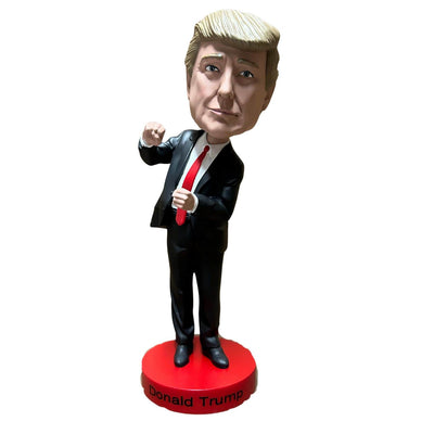 Dancing Trump Bobble Head in a black suit with a red tie, energetically posed on a red base, bringing a humorous vibe to any display area.