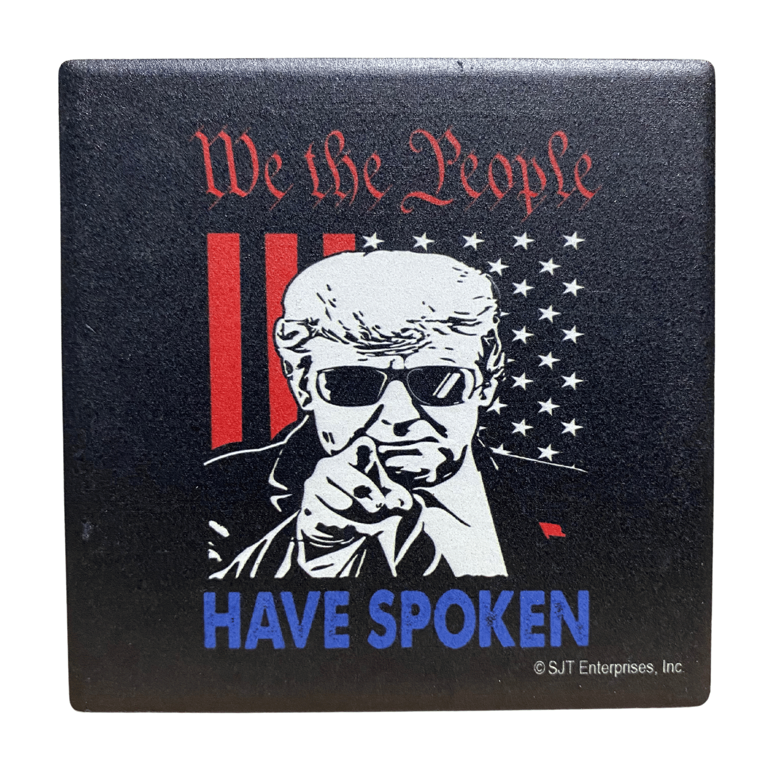 Donald Trump We The People square absorbable stone coaster featuring Trump in aviator sunglasses and patriotic text displayed on a wooden table.