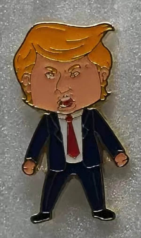 Happy Trump Lapel Pin features vibrant colors and a stylish design, displayed on a blue jacket in a casual setting.