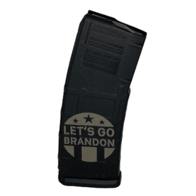 Let's Go Brandon 5.56 30-Round PMAG featuring a playful custom print, displayed alongside a firearm on a shooting range.