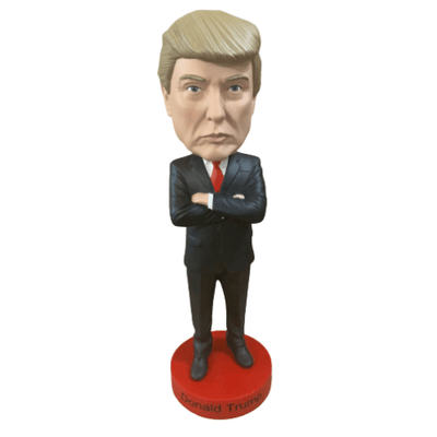 President Trump Royal Bobblehead showcasing a smiling Trump with a red tie, bobbling on a sturdy base in an office setting.