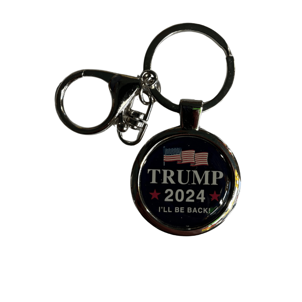 Trump 2024 I'll Be Back keychain featuring a silver-tone frame with round dark background, white lettering, red stars, and a patriotic flag graphic.