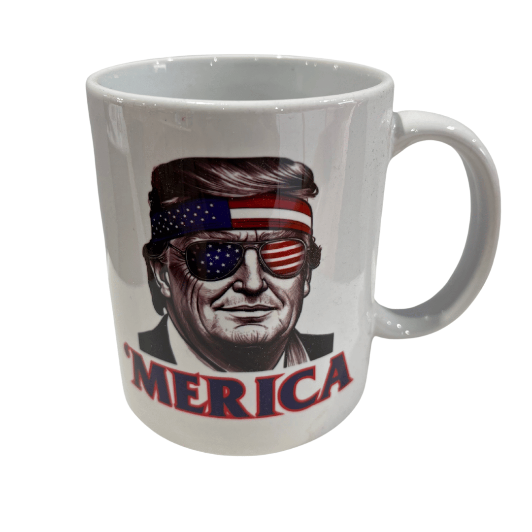 A Trump 'Merica Shades Mug showcases Donald Trump with American flag sunglasses and a stars-and-stripes bandana, capturing patriotic spirit.