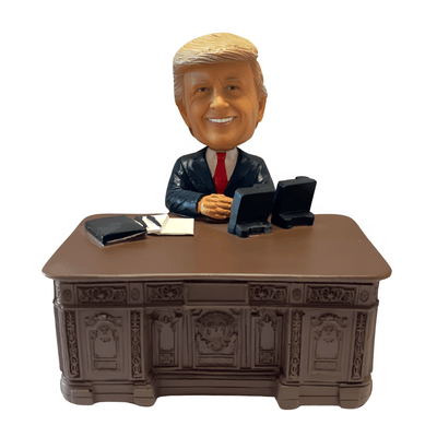 Trump Resolute Desk Bobble Head collectible figurine, depicting former President Trump seated at the historic Resolute Desk, showcasing intricate details.