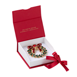 A 2.1-inch gold-plated pewter wreath brooch inspired by White House Christmas décor — a timeless, patriotic accessory that brings holiday spirit to your outfit.